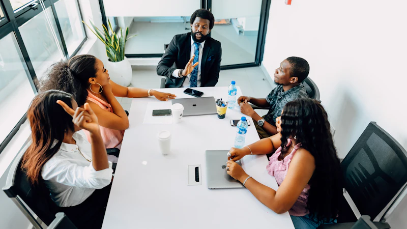 A small team meeting around a table with laptops